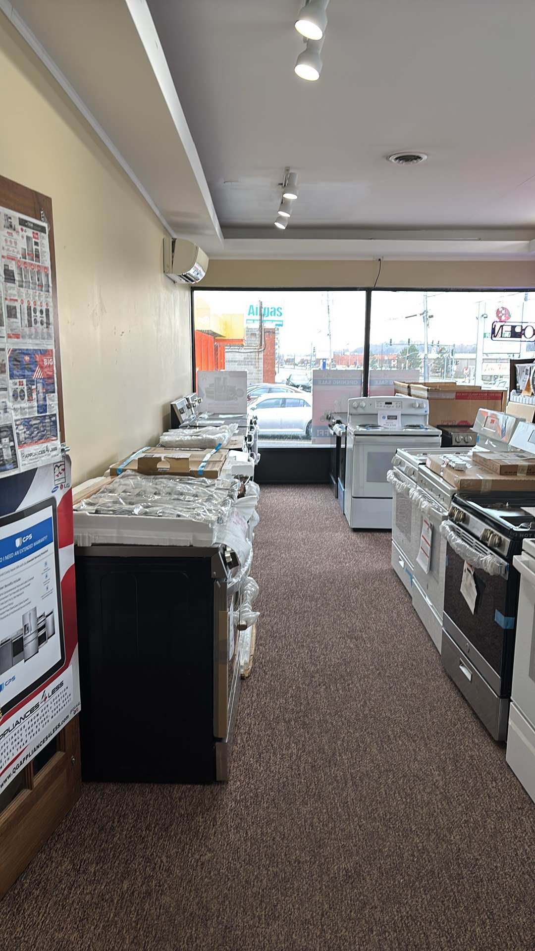 Row of new and scratch-and-dent ranges on the retail showroom floor, with the front window looking out onto Erie Blvd